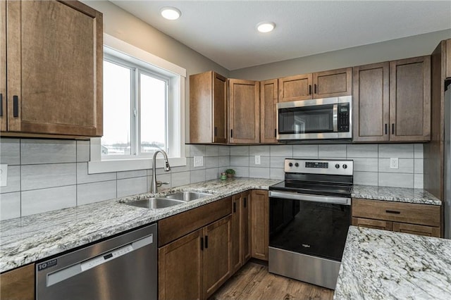 2105 Elk Run Dr SE, Pine Island, MN 55963 - kitchen featuring appliances with stainless steel finishes, light stone countertops, backsplash, wood finished floors, and recessed lighting