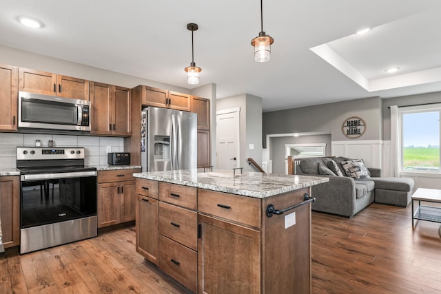 2105 Elk Run Dr SE, Pine Island, MN 55963 - kitchen featuring appliances with stainless steel finishes, dark wood-type flooring, decorative light fixtures, and tasteful backsplash