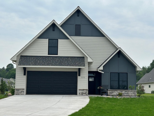 2461 Sharon Ln, Hudson, WI 54016 - view of front of property featuring driveway, a front yard, stone siding, and a shingled roof