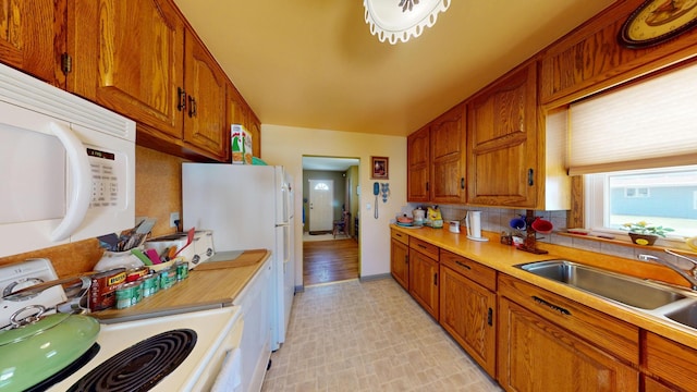 715 3rd Ave, Albert Lea, MN 56007 - kitchen featuring white appliances, brown cabinetry, light countertops, and tasteful backsplash