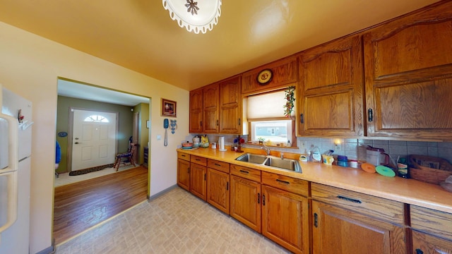 715 3rd Ave, Albert Lea, MN 56007 - kitchen featuring brown cabinets, light countertops, tasteful backsplash, and light wood finished floors