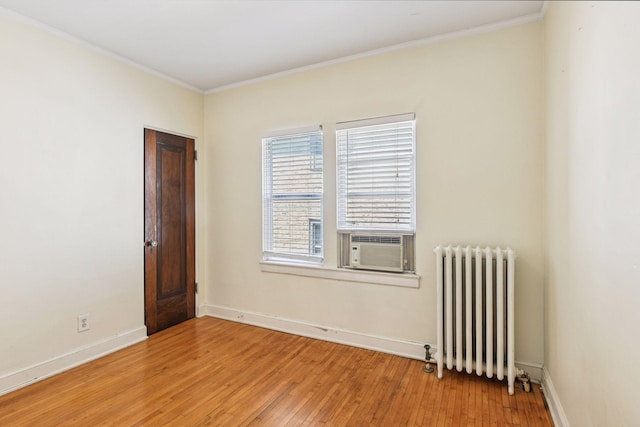 3252 Fremont Ave S Unit 102, Minneapolis, MN 55408 - empty room featuring radiator, light wood-type flooring, crown molding, and cooling unit