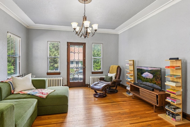 3252 Fremont Ave S Unit 102, Minneapolis, MN 55408 - living room with healthy amount of natural light, a chandelier, wood finished floors, ornamental molding, and radiator heating unit