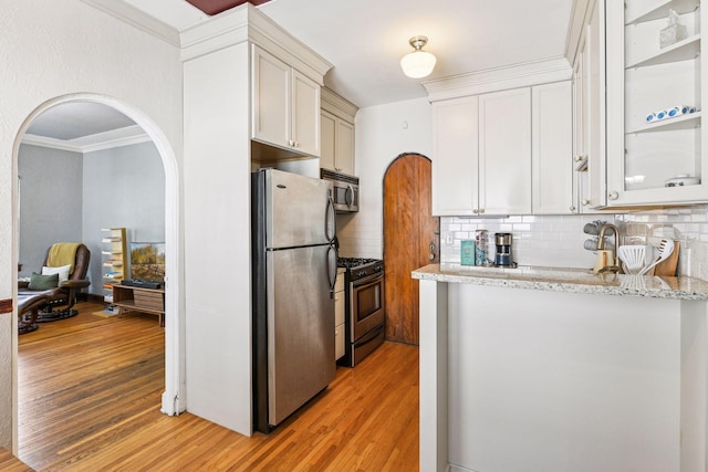 3252 Fremont Ave S Unit 102, Minneapolis, MN 55408 - kitchen featuring stainless steel appliances, light wood finished floors, arched walkways, decorative backsplash, and crown molding