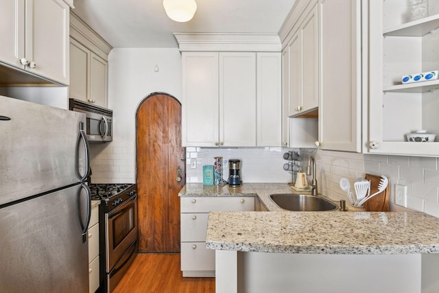 3252 Fremont Ave S Unit 102, Minneapolis, MN 55408 - kitchen featuring stainless steel appliances, open shelves, light wood-style flooring, decorative backsplash, and light stone countertops