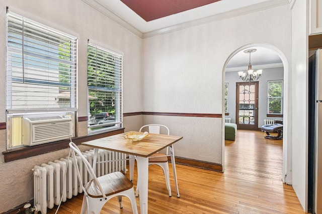 3252 Fremont Ave S Unit 102, Minneapolis, MN 55408 - dining area with ornamental molding, radiator, a chandelier, a textured wall, and light wood-style flooring