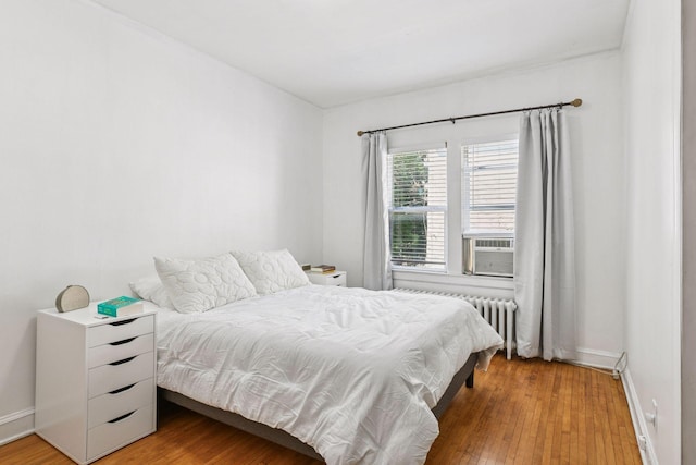 3252 Fremont Ave S Unit 102, Minneapolis, MN 55408 - bedroom with radiator heating unit, wood finished floors, and cooling unit