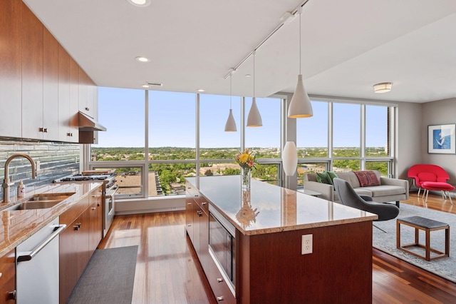 222 2nd St SE Unit 1503, Minneapolis, MN 55414 - kitchen with dishwasher, built in microwave, high end stainless steel range oven, wood finished floors, and under cabinet range hood