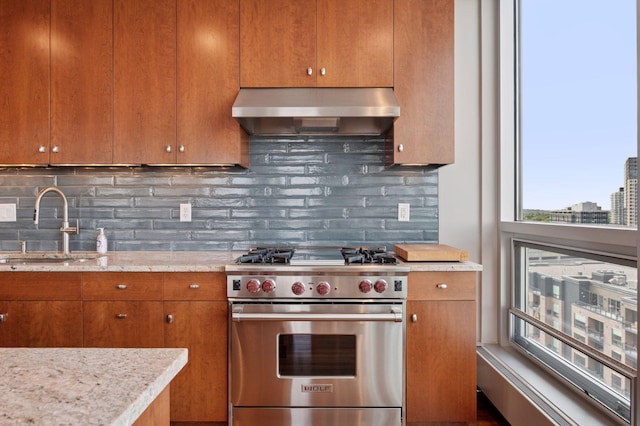 222 2nd St SE Unit 1503, Minneapolis, MN 55414 - kitchen with luxury range, range hood, brown cabinets, and backsplash