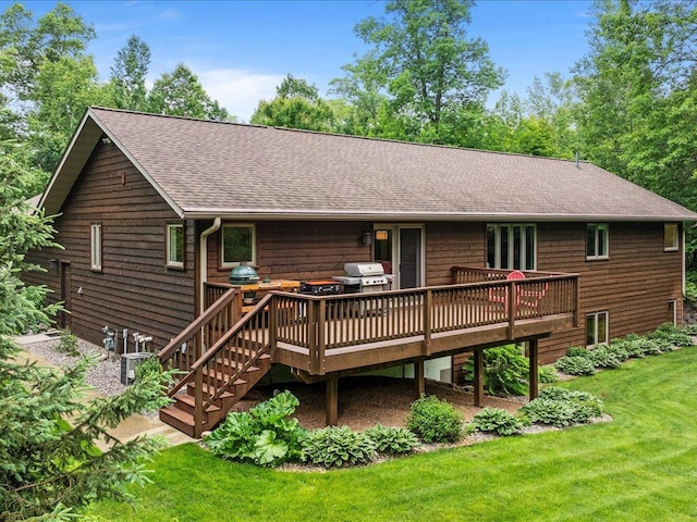 11034 Forest View Ct SW, Nisswa, MN 56468 - rear view of house featuring a shingled roof, a wooden deck, and a lawn