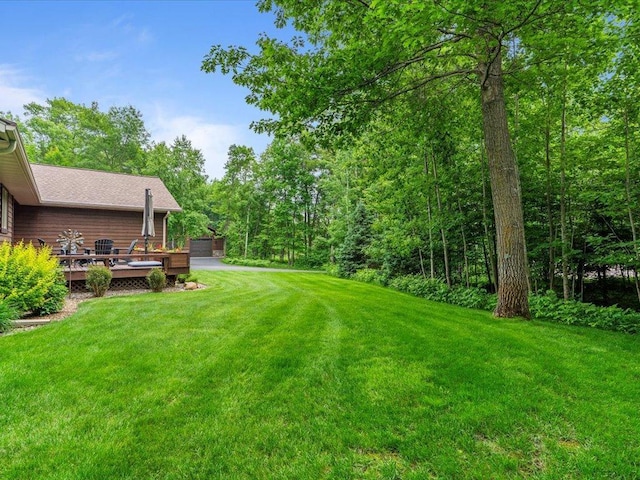 11034 Forest View Ct SW, Nisswa, MN 56468 - view of green lawn featuring a wooden deck and a detached garage