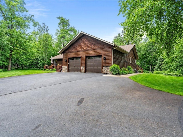 11034 Forest View Ct SW, Nisswa, MN 56468 - view of front of house featuring asphalt driveway, an attached garage, a front lawn, and stone siding