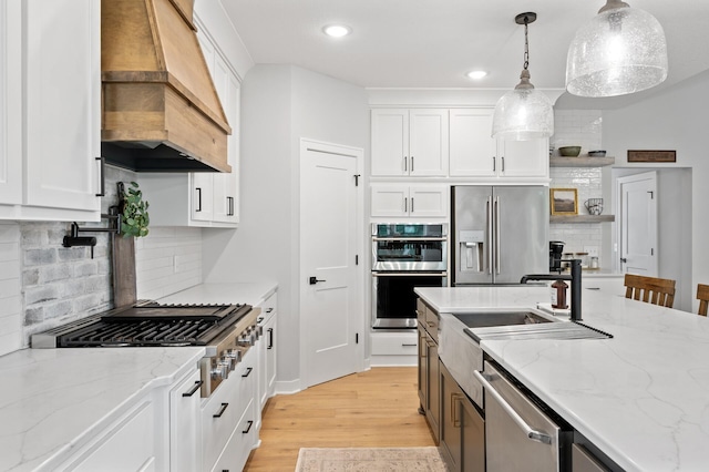 4452 167th Ave NW, Andover, MN 55304 - kitchen with appliances with stainless steel finishes, custom range hood, white cabinets, light wood-style floors, and decorative backsplash