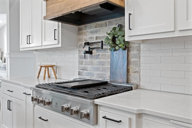 4452 167th Ave NW, Andover, MN 55304 - kitchen featuring stainless steel gas cooktop, premium range hood, backsplash, white cabinetry, and light stone countertops