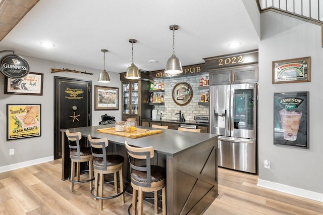 4452 167th Ave NW, Andover, MN 55304 - kitchen with stainless steel appliances, open shelves, dark countertops, a center island, and light wood-style flooring