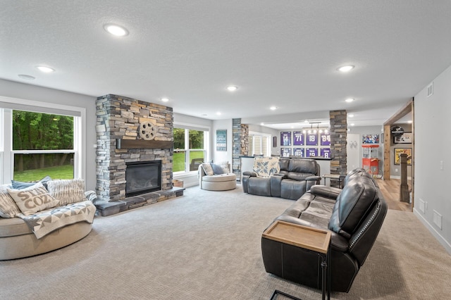 4452 167th Ave NW, Andover, MN 55304 - living room featuring decorative columns, carpet floors, a stone fireplace, recessed lighting, and a textured ceiling