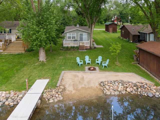 7315 120th St NW, Annandale, MN 55302 - back of property featuring a fire pit, a yard, a wooden deck, and an outdoor structure