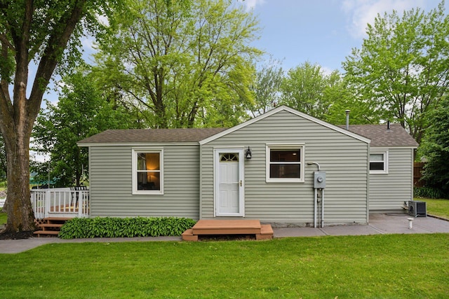 7315 120th St NW, Annandale, MN 55302 - rear view of property featuring a yard, roof with shingles, a wooden deck, and a patio area
