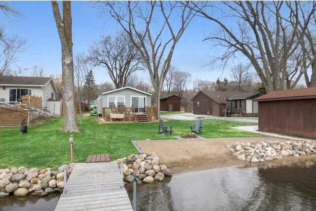 7315 120th St NW, Annandale, MN 55302 - dock area with a deck with water view, a fire pit, a lawn, and a residential view
