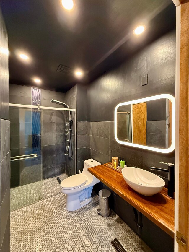 14303 Utica Ave, Savage, MN 55378 - bathroom featuring tile walls, a stall shower, recessed lighting, tile patterned flooring, and vanity