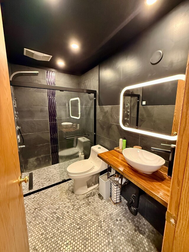 14303 Utica Ave, Savage, MN 55378 - bathroom featuring tile walls, a shower stall, and recessed lighting