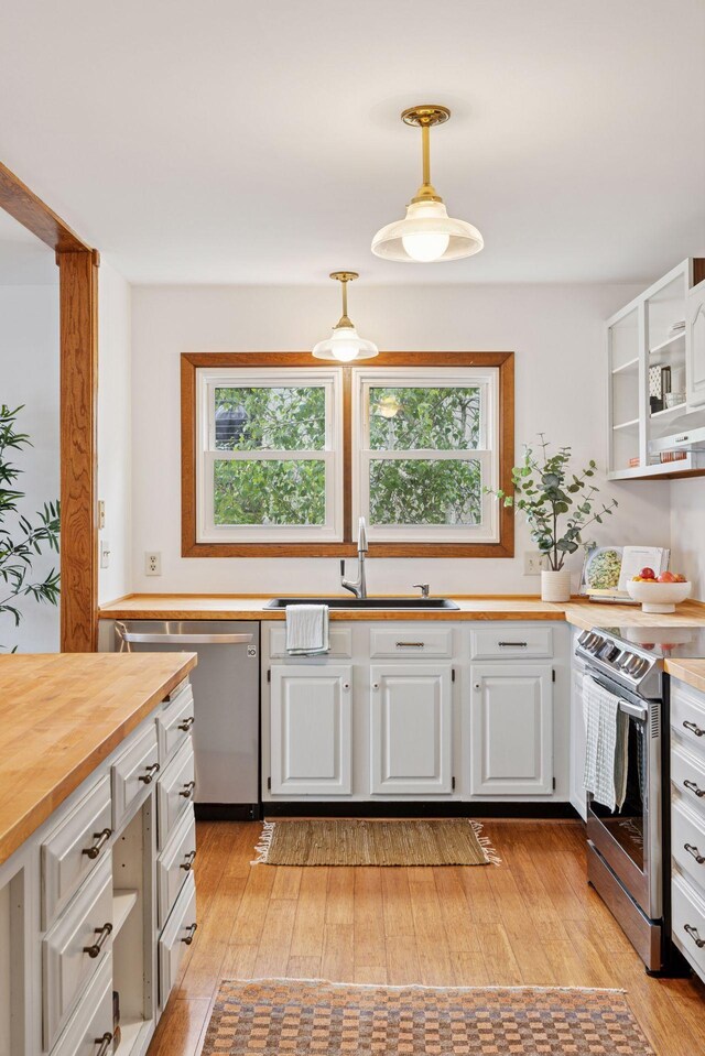 301 3rd St S Unit 302, Stillwater, MN 55082 - kitchen featuring appliances with stainless steel finishes, butcher block counters, white cabinetry, and plenty of natural light