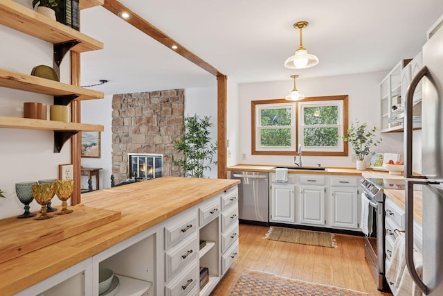 301 3rd St S Unit 302, Stillwater, MN 55082 - kitchen with appliances with stainless steel finishes, open shelves, butcher block counters, light wood-type flooring, and pendant lighting