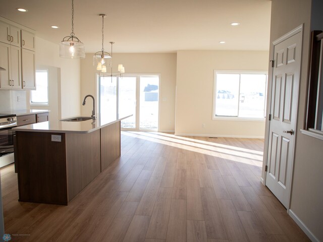 302 Neuman Blvd, Colfax, ND 58018 - kitchen with wood finished floors, light countertops, a center island with sink, plenty of natural light, and recessed lighting