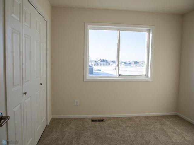 302 Neuman Blvd, Colfax, ND 58018 - unfurnished bedroom featuring multiple windows, carpet, and a closet