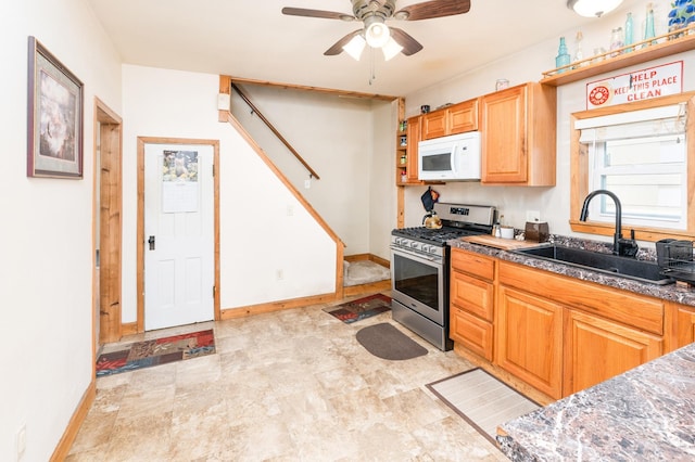 14 3rd St, Proctor, MN 55810 - kitchen featuring gas range, white microwave, and a ceiling fan