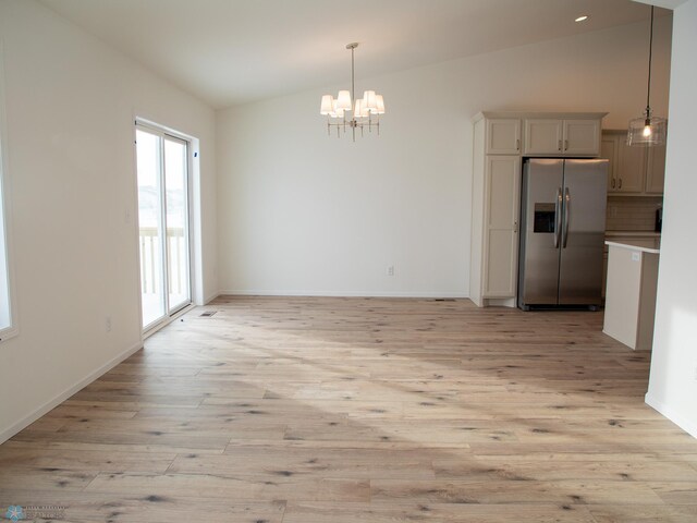 6310 83rd Ave S, Horace, ND 58047 - unfurnished dining area featuring vaulted ceiling, a chandelier, and light wood-style flooring