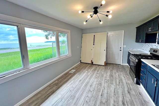 7165 US Highway 169, Garrison, MN 56450 - kitchen featuring stainless steel gas range oven, a chandelier, a water view, light wood finished floors, and blue cabinetry
