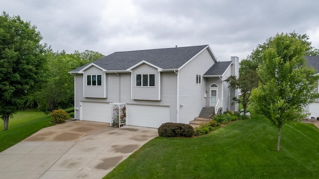 609 Main St E, Wabasha, MN 55981 - view of front facade with an attached garage, concrete driveway, a front yard, and a shingled roof