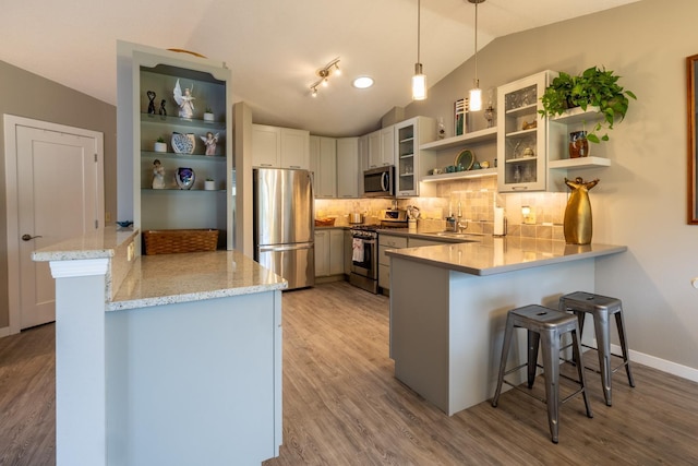 609 Main St E, Wabasha, MN 55981 - kitchen featuring appliances with stainless steel finishes, open shelves, a peninsula, light wood-style flooring, and vaulted ceiling