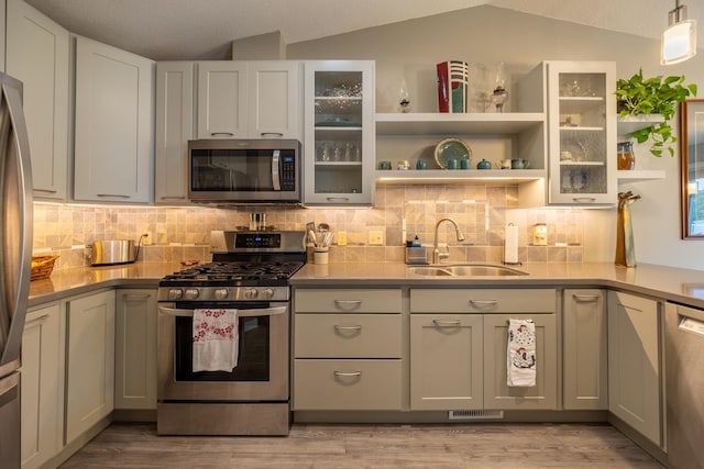 609 Main St E, Wabasha, MN 55981 - kitchen with appliances with stainless steel finishes, backsplash, light wood-style flooring, lofted ceiling, and light countertops