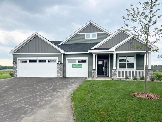 20264 Marsh Ct, Rogers, MN 55311 - craftsman-style home with asphalt driveway, stone siding, a front lawn, and board and batten siding
