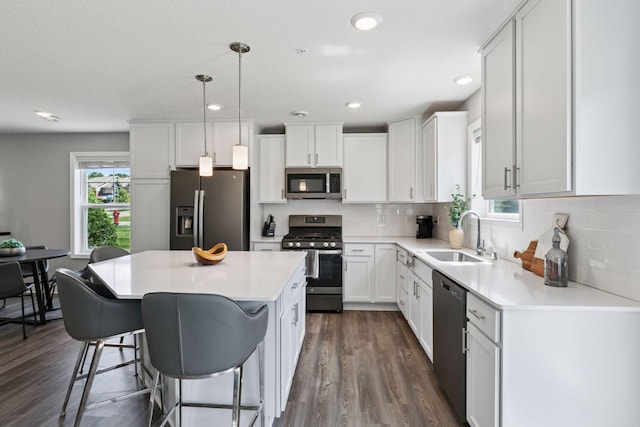 9462 Bridle Way, Victoria, MN 55386 - kitchen with appliances with stainless steel finishes, a kitchen island, white cabinets, dark wood-type flooring, and light countertops