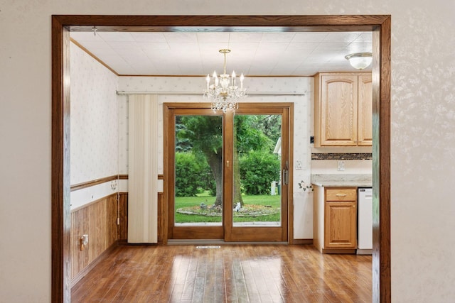 704 Highland Dr, New Prague, MN 56071 - entryway with wallpapered walls, wood-type flooring, a chandelier, crown molding, and a wainscoted wall