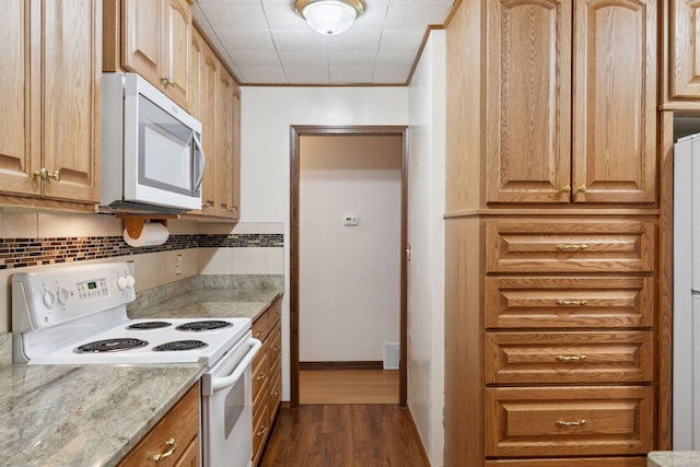 704 Highland Dr, New Prague, MN 56071 - kitchen featuring stainless steel microwave, white range with electric stovetop, dark wood-type flooring, backsplash, and light stone counters