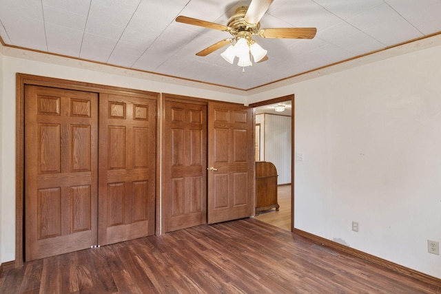 704 Highland Dr, New Prague, MN 56071 - unfurnished bedroom with dark wood-style flooring, a closet, and a ceiling fan