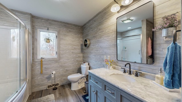 31340 Indigo Rd, Fountain, MN 55935 - full bathroom featuring vanity, wooden walls, shower / bath combination with glass door, and wood finished floors