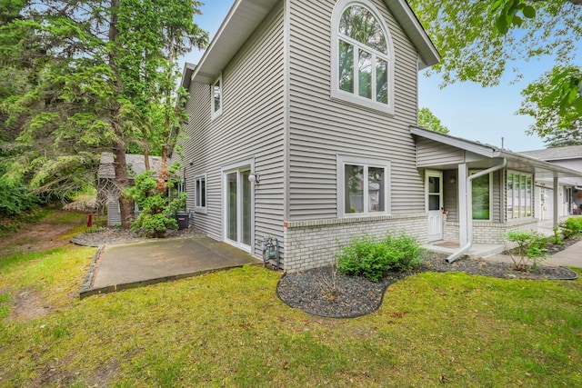 2513 Sumac Rdg, White Bear Lake, MN 55110 - view of property exterior with a patio area, a lawn, and brick siding