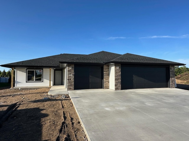 76 Meadow Ln, Cold Spring, MN 56320 - prairie-style house with a garage, concrete driveway, stone siding, and a shingled roof