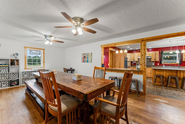 42118 Lowden Ave, Sunrise Twp, MN 55032 - dining area featuring wood finished floors, a ceiling fan, and a textured ceiling