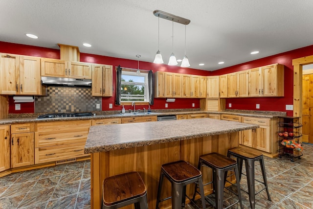 42118 Lowden Ave, Sunrise Twp, MN 55032 - kitchen featuring under cabinet range hood, a breakfast bar, appliances with stainless steel finishes, a kitchen island, and recessed lighting
