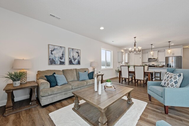1418 Cedar Ln, Litchfield, MN 55355 - living room featuring wood finished floors, a chandelier, and recessed lighting