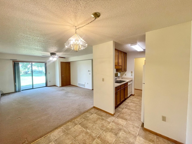401 County Road 5 Unit 102, Springfield, MN 56087 - kitchen featuring a textured ceiling, a chandelier, freestanding refrigerator, light countertops, and brown cabinets