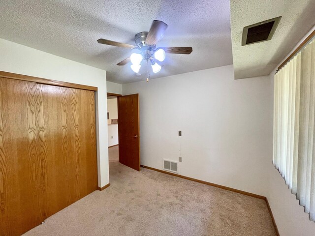401 County Road 5 Unit 102, Springfield, MN 56087 - unfurnished bedroom featuring carpet floors, a closet, a textured ceiling, and a ceiling fan