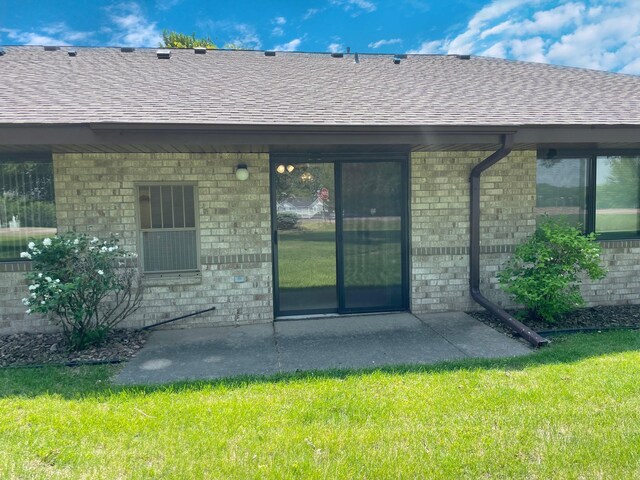 401 County Road 5 Unit 102, Springfield, MN 56087 - rear view of property featuring a shingled roof, brick siding, a yard, and a patio