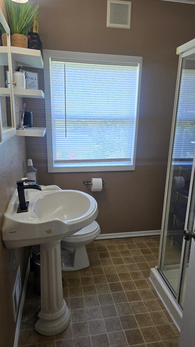 524 1st Ave SE, Wells, MN 56097 - full bathroom featuring a stall shower and baseboards